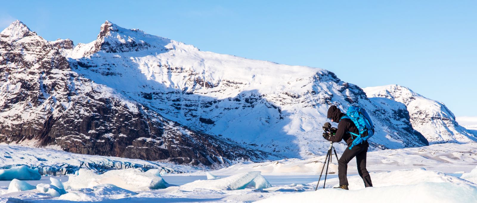 Eike is standing on glacier ice while filming mointains.