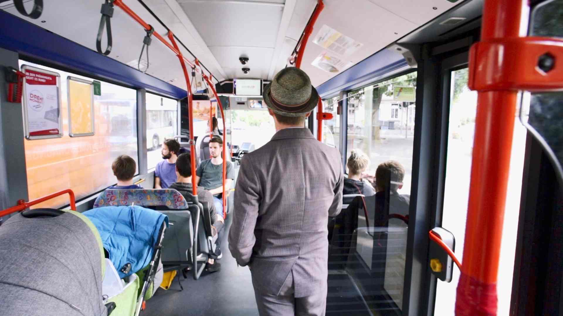 Men with suit and head standing in the bus.
